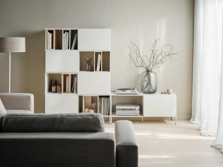  Salon w stylu minimalistycznym – regał Into na beżowej ścianie